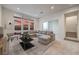 Bright living room with a comfortable sectional sofa, large windows with a beautiful sunset view at 3346 Esker Ridge Ave, Henderson, NV 89044