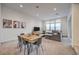 Open-concept living and dining area with modern furnishings and large windows showing off the city view at 3346 Esker Ridge Ave, Henderson, NV 89044