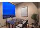A cozy outdoor patio with a dining table and seating with a view of the city skyline at dusk at 3346 Esker Ridge Ave, Henderson, NV 89044