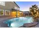Outdoor living features a covered patio, cozy seating, a built-in grill, and a sparkling pool with a waterfall at 3386 W Haleh Ave, Las Vegas, NV 89141