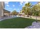 Spacious backyard featuring an artificial lawn, pool, mature trees, and an outdoor living area at 3386 W Haleh Ave, Las Vegas, NV 89141