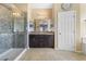 Bathroom with tiled shower, granite vanity with double sinks and framed mirrors at 3386 W Haleh Ave, Las Vegas, NV 89141
