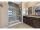 Bathroom showcasing tiled shower, granite vanity with double sinks and framed mirrors at 3386 W Haleh Ave, Las Vegas, NV 89141
