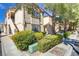 View of the condo's exterior featuring manicured landscaping with mature trees and shrubbery at 3660 Renovah St # 204, Las Vegas, NV 89129