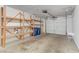 Attached garage with shelving and two blue trash receptacles at 3660 Renovah St # 204, Las Vegas, NV 89129