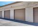 Three garages in a row with brown doors at 3660 Renovah St # 204, Las Vegas, NV 89129