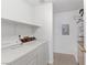 Well-lit laundry room features a washer, dryer, and shelving for convenient organization at 3660 Renovah St # 204, Las Vegas, NV 89129