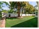Private backyard featuring synthetic lawn and mature palm trees, perfect for relaxation at 3684 Miguels Ln, Las Vegas, NV 89120