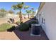 This backyard has decorative rock, palm trees, manicured shrubs, and block wall fencing for privacy at 3761 Tohono Canyon St, Las Vegas, NV 89147