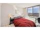 Comfortable bedroom with a red comforter and large window with city views at 3930 University Center Dr # 804, Las Vegas, NV 89119