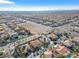 An aerial view shows an expansive neighborhood with terra cotta roofs and desert landscaping under a clear sky at 4024 Mansion Hall Ct, Las Vegas, NV 89129
