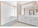 Bright bathroom featuring double vanity, soaking tub, and tile flooring at 4024 Mansion Hall Ct, Las Vegas, NV 89129