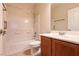 Bright bathroom with white tiled shower-tub, vanity with dark wood cabinets and tiled floor at 4125 Gliding Gulls Ave, North Las Vegas, NV 89084
