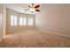 Spacious bedroom with neutral walls, plush carpet, ceiling fan, and a window with shutters at 4125 Gliding Gulls Ave, North Las Vegas, NV 89084
