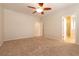 Spacious bedroom with neutral walls, plush carpet, ceiling fan, and an open doorway at 4125 Gliding Gulls Ave, North Las Vegas, NV 89084