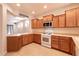 Open kitchen boasts wooden cabinets, updated appliances, and breakfast bar at 4125 Gliding Gulls Ave, North Las Vegas, NV 89084