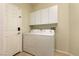 Laundry room featuring modern washer and dryer units with white cabinets above at 4125 Gliding Gulls Ave, North Las Vegas, NV 89084