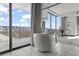 Bright bathroom with a modern soaking tub near large windows that offer stunning city views, a serene retreat at 4381 W Flamingo Rd # 922, Las Vegas, NV 89103