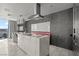 Contemporary kitchen featuring a marble island, sleek vent hood, and eye-catching chandelier, offering a modern cooking space at 4381 W Flamingo Rd # 922, Las Vegas, NV 89103