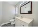 Neutral bathroom featuring a single sink vanity with a wood framed mirror and toilet at 4495 Park View Dr, Las Vegas, NV 89104