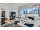 Modern living room featuring a white sectional sofa and stunning city views through large windows at 4525 Dean Martin Dr # 2001, Las Vegas, NV 89103