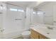 This well-lit bathroom includes a bathtub with shower, handrails, and a modern vanity, ensuring accessibility at 4629 Cattleman Ave, North Las Vegas, NV 89031