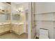 Bathroom with double sinks and vanities, tiled floors, and shelves for storage, offering functionality and comfort at 4629 Cattleman Ave, North Las Vegas, NV 89031