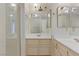 Bright bathroom featuring a shower and a vanity with double sinks and mirrors at 4629 Cattleman Ave, North Las Vegas, NV 89031