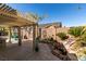 Charming backyard with a covered patio, rock garden and water feature, creating a serene and inviting outdoor space at 489 Beaconwood St, Henderson, NV 89052