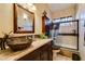 Stylish bathroom featuring a unique vessel sink, dark wood cabinetry, and a glass-enclosed shower at 489 Beaconwood St, Henderson, NV 89052
