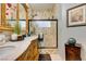 Bathroom with a beautifully tiled shower, decorative framed mirror, and a custom vanity at 489 Beaconwood St, Henderson, NV 89052