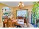 Dining room with chandelier, wooden table set, and arched entryway to living room at 489 Beaconwood St, Henderson, NV 89052