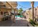 Relaxing backyard patio with an outdoor kitchen, barbecue and a refreshing swimming pool, perfect for entertaining at 489 Beaconwood St, Henderson, NV 89052