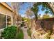 Landscaped side yard with a stone pathway, mature trees, shrubs and serene garden setting at 489 Beaconwood St, Henderson, NV 89052