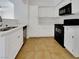A kitchen with white cabinets, countertops, and black appliances with tiled floors at 7255 W Sunset Rd # 1116, Las Vegas, NV 89113
