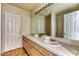 Well-lit bathroom featuring double sinks, tile countertops, and a large mirror at 7820 Wedlock Ln, Las Vegas, NV 89129
