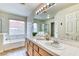 Bathroom featuring double sinks with a garden tub perfect for relaxation at 7820 Wedlock Ln, Las Vegas, NV 89129