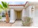 Inviting front entrance with covered porch, textured walls, and a green front door at 7820 Wedlock Ln, Las Vegas, NV 89129