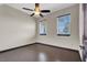 Bedroom with two sunny windows, dark hardwood floors, and a modern ceiling fan, perfect for relaxation at 822 Fairview Dr, Henderson, NV 89015