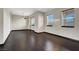 Bright, airy living room with dark floors, three windows, and neutral walls at 822 Fairview Dr, Henderson, NV 89015
