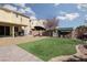 Landscaped backyard with artificial turf, seating area, patio, and custom dog kennel for outdoor enjoyment at 8501 Bellery Ave, Las Vegas, NV 89143