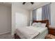 Cozy bedroom featuring a wooden bed frame, plush blanket, and light-filled window with elegant curtains at 8501 Bellery Ave, Las Vegas, NV 89143