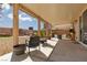Covered patio featuring stylish outdoor furniture, desert landscaping, and scenic views for relaxation and entertainment at 8501 Bellery Ave, Las Vegas, NV 89143