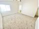 Spacious bedroom with neutral carpet, ceiling fan, and adjacent bathroom provides a tranquil retreat at 8748 Tomnitz Ave # 103, Las Vegas, NV 89178