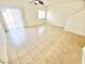 Bright living room features neutral tile flooring and natural light from sliding glass door at 8748 Tomnitz Ave # 103, Las Vegas, NV 89178