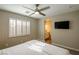 Bright bedroom featuring plantation shutters, a ceiling fan, and ensuite bathroom at 9446 Bondeno St, Las Vegas, NV 89123