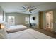 Spacious bedroom featuring two beds, plantation shutters, ceiling fan, and mounted television at 9446 Bondeno St, Las Vegas, NV 89123