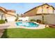Inviting kidney-shaped pool with small waterfall feature surrounded by desert landscaping and sunny skies at 9446 Bondeno St, Las Vegas, NV 89123