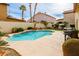 Inviting kidney-shaped pool with small waterfall feature surrounded by lush landscaping, barbecue and lounge seating at 9446 Bondeno St, Las Vegas, NV 89123