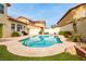 Inviting kidney-shaped pool with small waterfall feature surrounded by desert landscaping and sunny skies at 9446 Bondeno St, Las Vegas, NV 89123